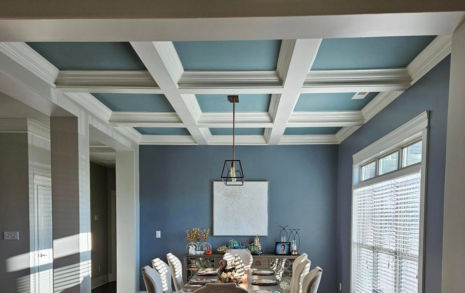 Finished dining room with blue walls and crisp white coffered ceiling trim in Melbourne, FL