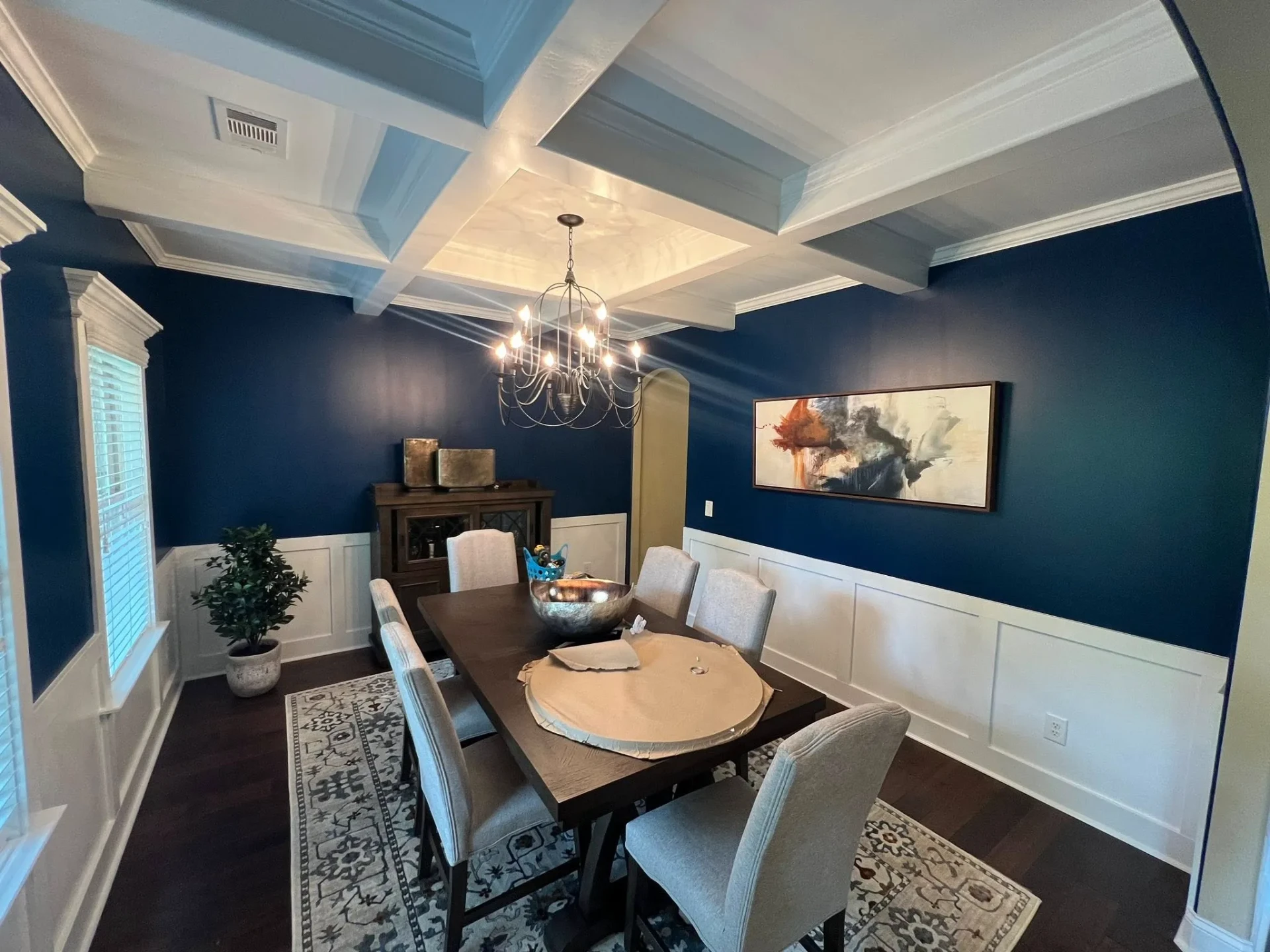 Finished dining room with deep navy walls, white coffered ceiling and wainscoting in Brevard County, FL