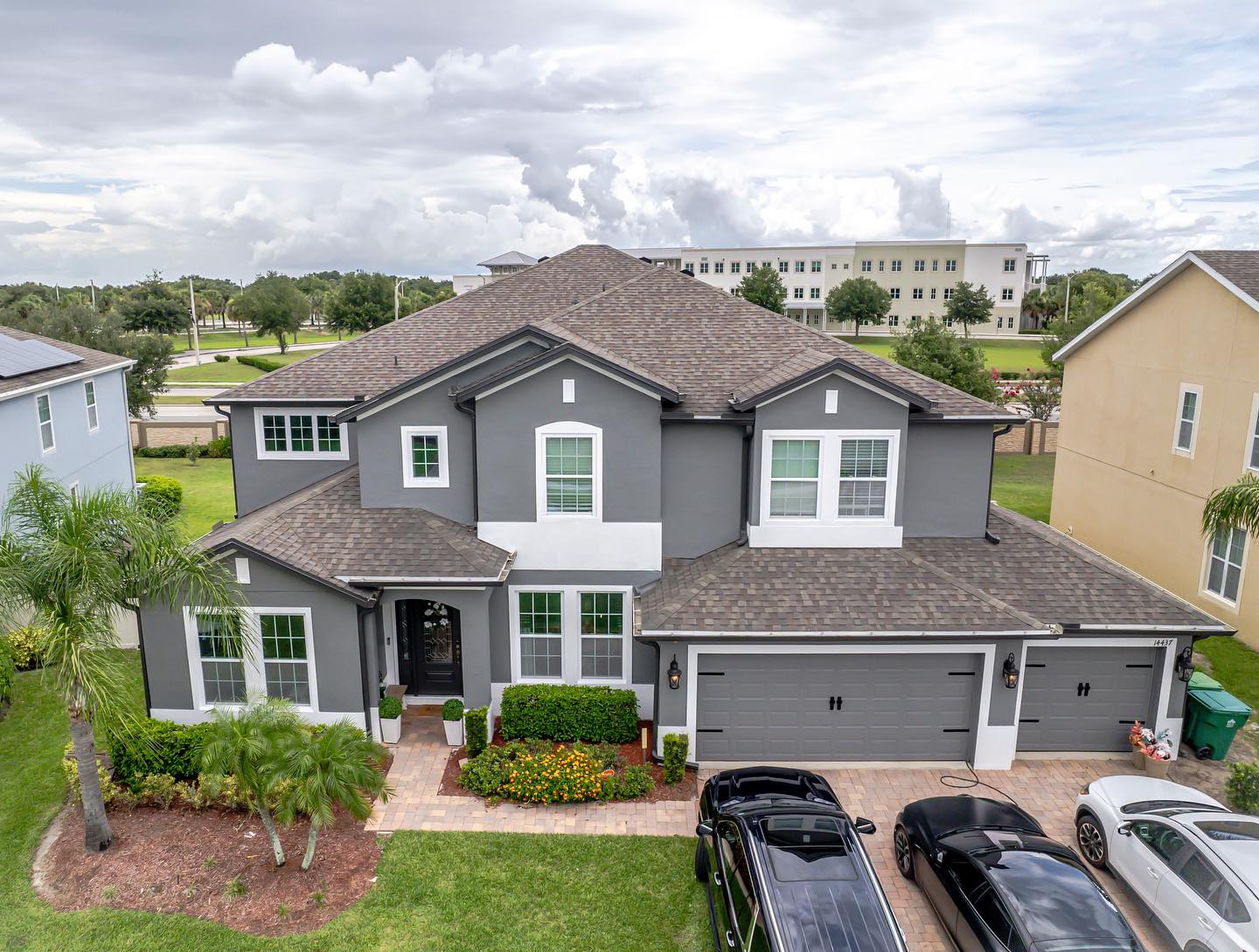 Finished exterior repaint of a two-story Florida stucco home in dark gray with white trim in Viera, FL