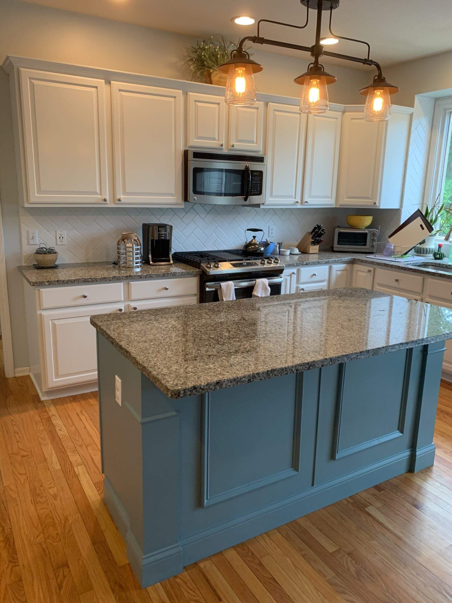 Refinished white kitchen cabinets with a painted blue island in Melbourne, FL
