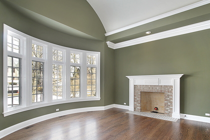 Finished living room with olive green walls, white crown molding and painted fireplace mantel in Rockledge, FL