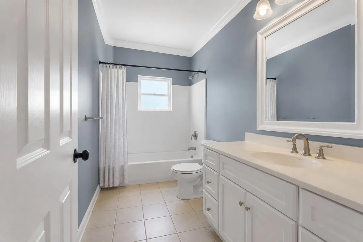 Same bathroom after painting with coastal blue-gray satin walls and white trim in Cocoa Beach, FL
