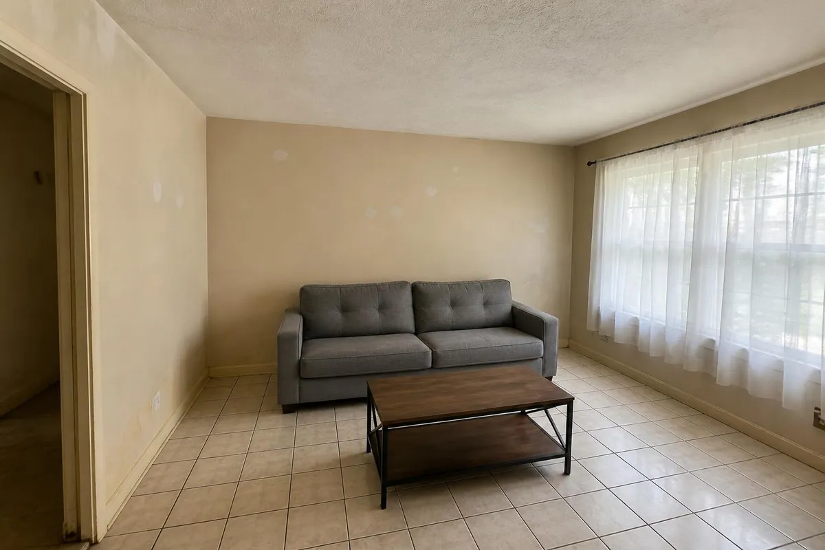 Living room with dated scuffed wall paint before interior painting in Melbourne, FL