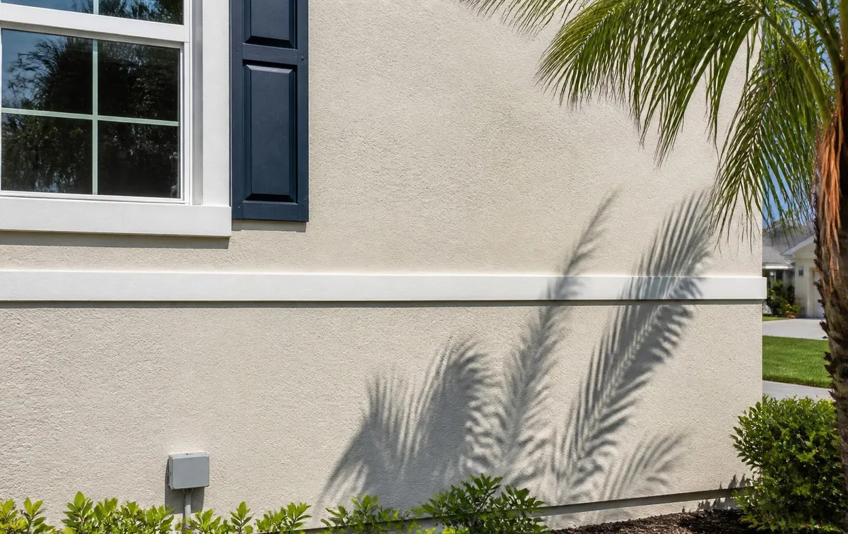 Repaired and repainted off-white stucco wall with white trim and navy shutter on a Brevard County, FL home